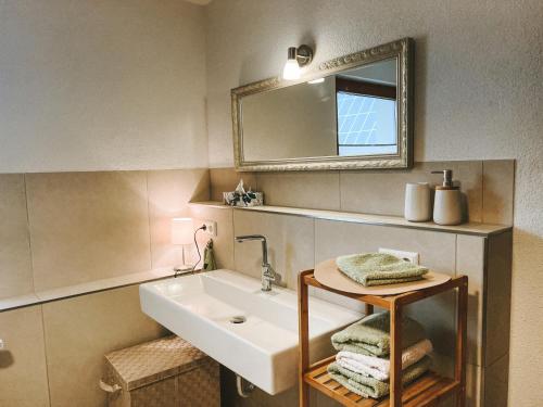 a bathroom with a sink and a mirror and towels at Dorfplatz Loft - großzügig & modern nur 10Min von Rothenburg odT in Schrozberg