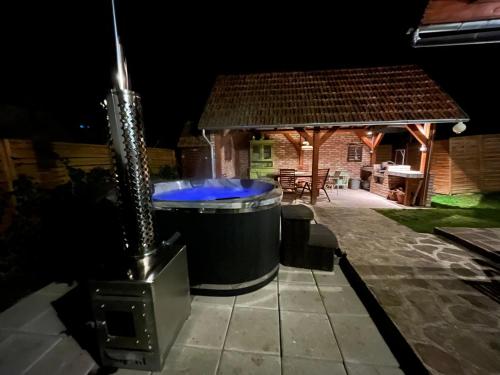 a hot tub in the backyard of a house at night at Padláskincsek Vendégház in Nagybörzsöny