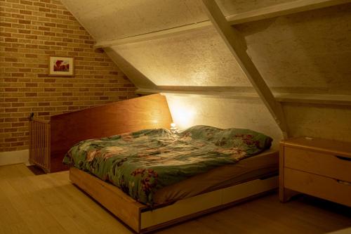 Ce lit se trouve dans une chambre dotée d'un mur en briques. dans l'établissement Landelijk Huisje te Houtem, à Furnes