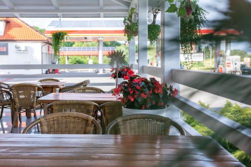 an outdoor restaurant with tables and chairs and flowers at Noclegi Grill Solo in Sandomierz