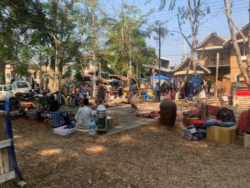 a group of people sitting around in a market at บ้านใจแปงโฮมสเตย์ Ban Jaipang Homestay in Pai