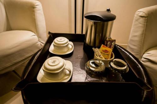 a table with a tray with cups and a coffee pot at Rysara Hotel in Dakar