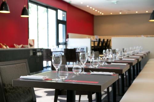 a row of wine glasses on tables in a restaurant at Mercure Bordeaux Lac in Bordeaux