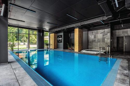 a large swimming pool with blue water in a building at RS SUITES PRESTIGE Racławickie 10 "best view" HOME & SPA in Lublin