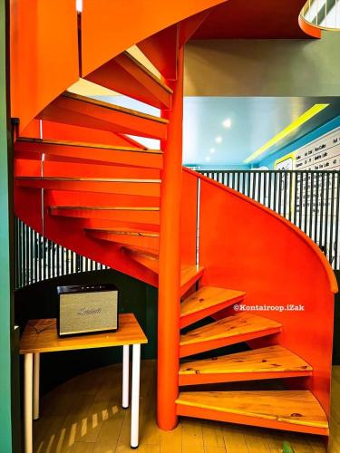 an orange spiral staircase with a table and a bench at Naris phu view resort in Ban Pan Cho