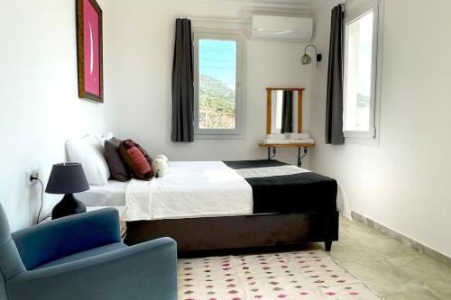 1 dormitorio con 1 cama y 1 silla azul en Ozy Apart Bayındır, en Kas