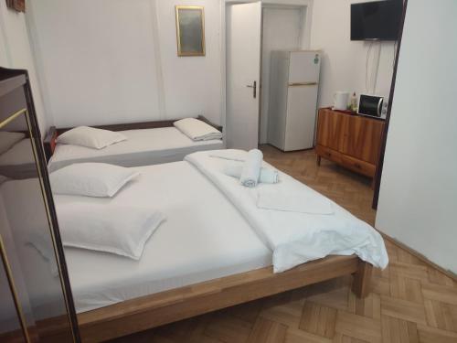 een kamer met 3 bedden en een koelkast bij Iancu Apartments in Boekarest