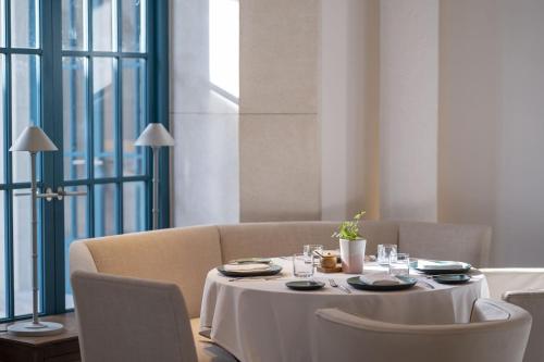 a dining room table with a white table cloth and chairs at AYANA Segara Bali in Jimbaran