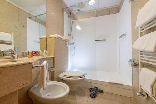 a bathroom with a toilet and a sink and a shower at Hotel Duomo in Orvieto