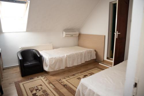 une petite pièce avec un lit et une chaise dans l'établissement Motel Moara Veche, à Săcălăşeni