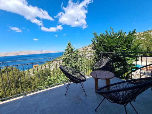 a balcony with a table and chairs and a view of the water at Casa sole infinito in Senj