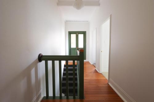 a hallway with a stairway with a stair case at Discover The Rocks - Historical Terrace House in Sydney