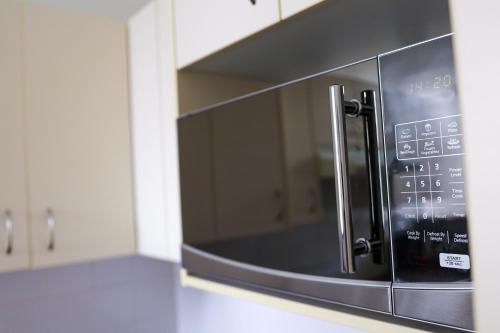 a microwave oven sitting on top of a kitchen counter at Discover The Rocks - Historical Terrace House in Sydney
