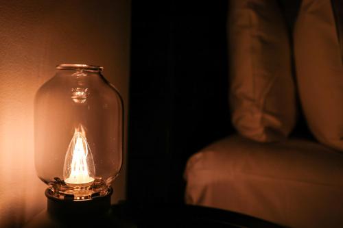 a glass jar with a lit candle in it at Discover The Rocks - Historical Terrace House in Sydney