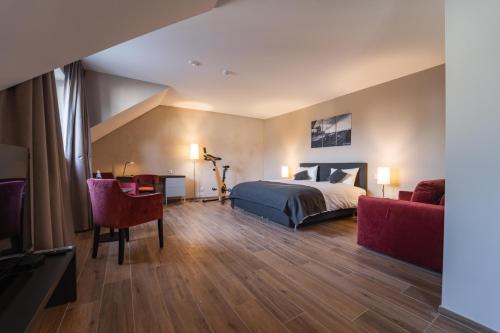 um quarto de hotel com uma cama e duas cadeiras em Hotel Monvillage em Mondercange