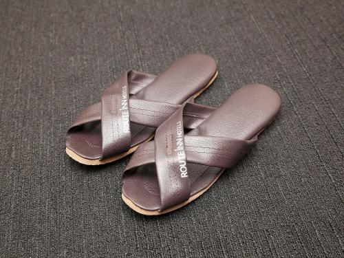 a pair of brown sandals sitting on a table at Hotel Route-Inn Nagahama Inter in Nagahama