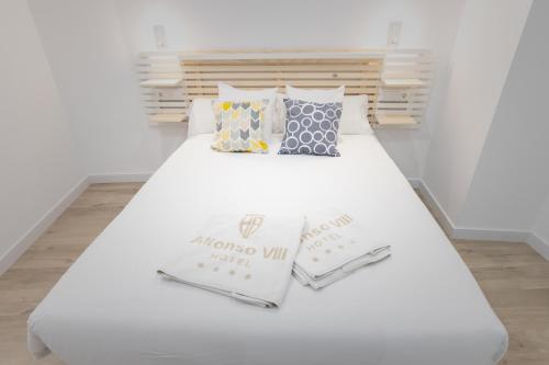 ein weißes Bett mit zwei Kissen darüber in der Unterkunft Apartamentos Soria Suites in Soria