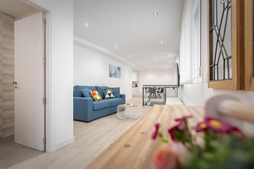ein Wohnzimmer mit einem blauen Sofa und einem Tisch in der Unterkunft Apartamentos Soria Suites in Soria