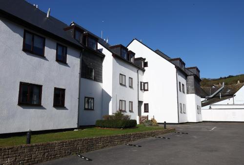 a row of white buildings with a parking lot at Starfish Apartment in Beer