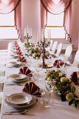 a long table with plates and glasses and flowers at Hotel Szyndzielnia Eco in Bielsko-Biała