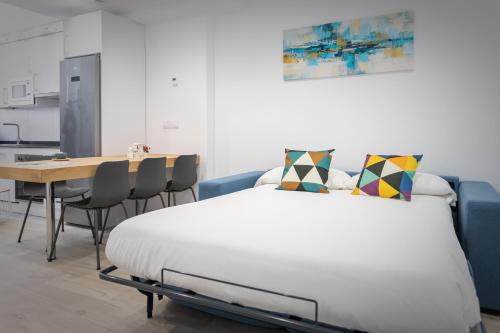 a bedroom with a bed and a table and a kitchen at Apartamentos Soria Suites in Soria