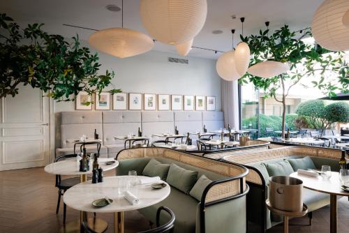 a restaurant with tables and chairs and a large window at Pillows Grand Boutique Hotel Reylof Ghent in Ghent