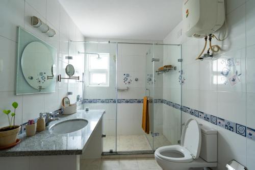 a bathroom with a toilet and a sink and a shower at Luho 206 in Bangalore