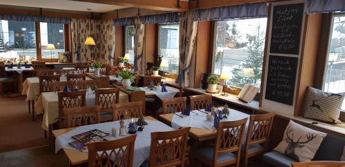 a dining room with tables and chairs in a restaurant at Landhaus Eickler in Baiersbronn
