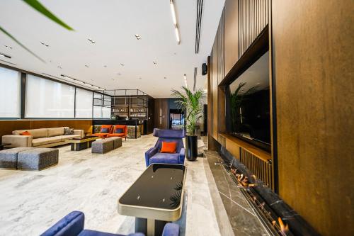 a lobby with blue chairs and a flat screen tv at The Kailyn Hotels&Suites Ataşehir in Istanbul