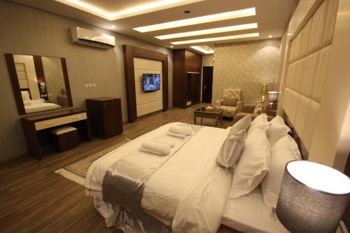 una camera d'albergo con un grande letto e un bagno di Suit los a Az̧ Z̧afīr