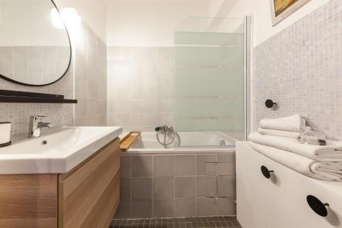 une salle de bain avec un lavabo, une baignoire et un miroir dans l'établissement Sacha, à Marseille