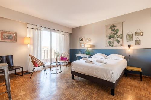 une chambre avec un lit, une table et des chaises dans l'établissement Sacha, à Marseille