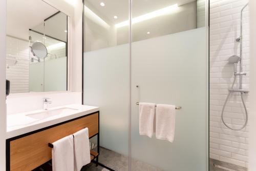 y baño con lavabo y ducha. en SADU hotel, en Almaty