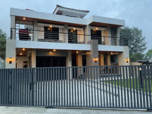 une maison avec une clôture devant elle dans l'établissement Hidden Hill Villa Kota Bunga by Citrus House, à Cipanas