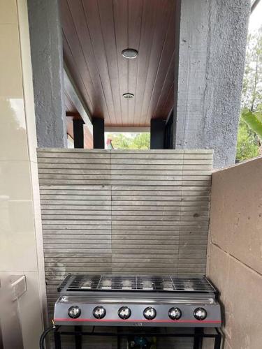a stove top oven in a kitchen with a wall at Hidden Hill Villa Kota Bunga by Citrus House in Cipanas