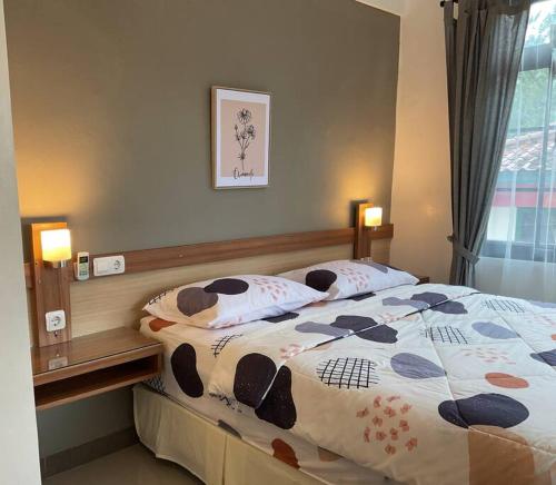 a bedroom with a bed with two pillows on it at Hidden Hill Villa Kota Bunga by Citrus House in Cipanas