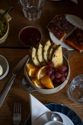 een tafel met een fruitschaal en een bord pizza bij Hotel Nestor & Restaurant Back Pocket in Korppoo