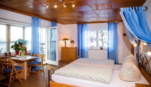 een slaapkamer met een bed met blauwe gordijnen en een tafel bij Ferienwohnung "Gaby" in Freyung