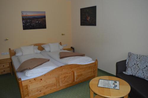 a bed in a room with a table and a couch at Landhaus Eickler in Baiersbronn