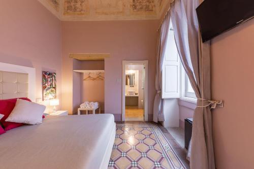 a bedroom with a large bed and a window at Palazzo Arco Cadura Hotel & Spa in Galatina