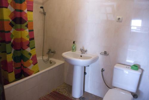 y baño con lavabo, aseo y ducha. en Self-catering Apartment w/ Terrace, en Tarrafal