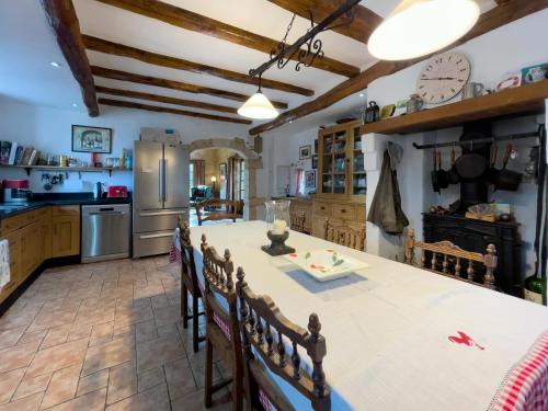 Una cocina con una mesa larga y sillas en una habitación. en La chaumière, en Varneil