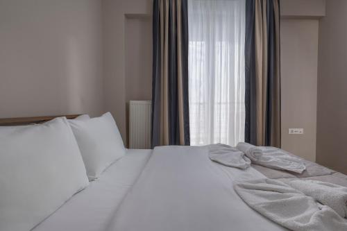 a white bed in a bedroom with a window at Antigonidon Square in Thessaloniki