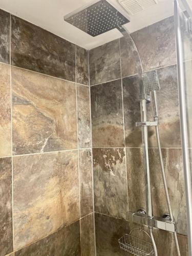 a shower with a shower head in a bathroom at Gillygate Holiday Apartment in York