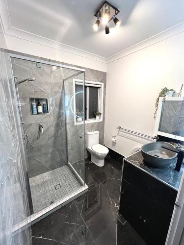 a bathroom with a shower and a toilet and a sink at Berghofen in Mount Tamborine