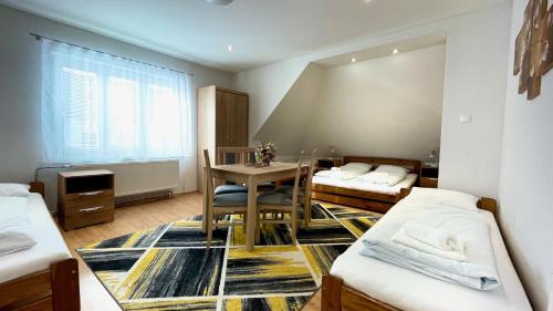 a room with two beds and a table in it at Ubytovanie Athéna in Poprad