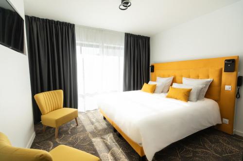 una camera d'albergo con un grande letto e una sedia di Le Barracuda & Spa, Centre Port, pieds dans l'eau, vue mer a Brest