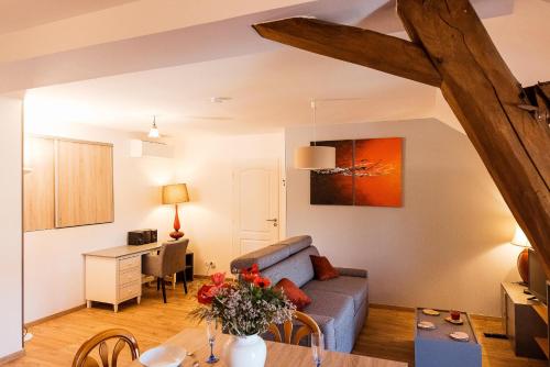 a living room with a couch and a table at Studio confortable, parking et jardin in Buchères