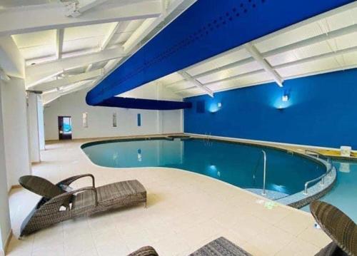 a large swimming pool with a blue wall at Number 57 Brynteg in Caernarfon
