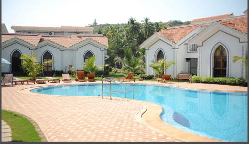 a large swimming pool in front of a house at Riviera palms 1 Luxury 1 BHK apartment with Swimmimg Pool view- Arpora - near baga beach in Old Goa